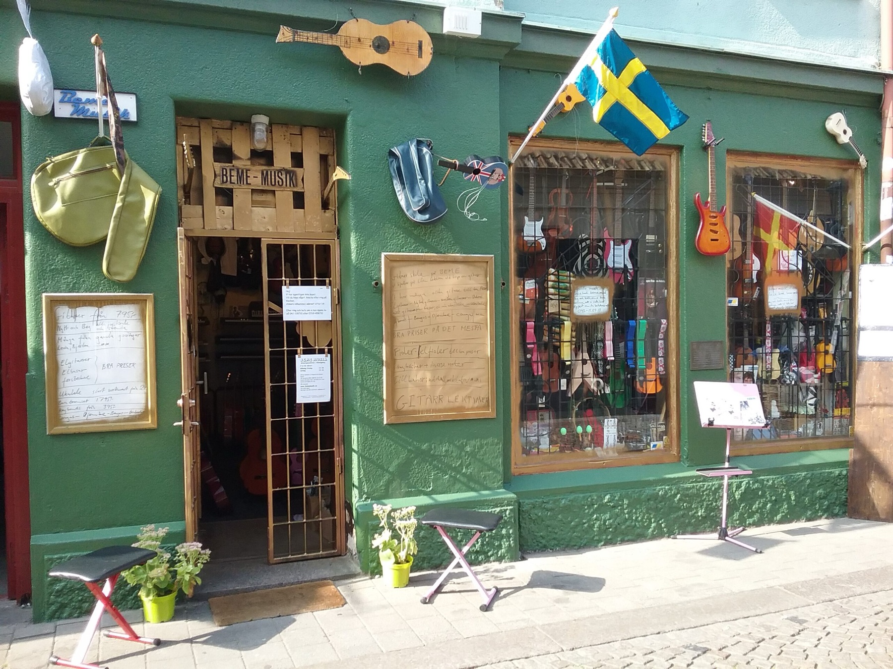 Beme Musiks gröna butiksfasad med skyltfönster fullt av gitarrer